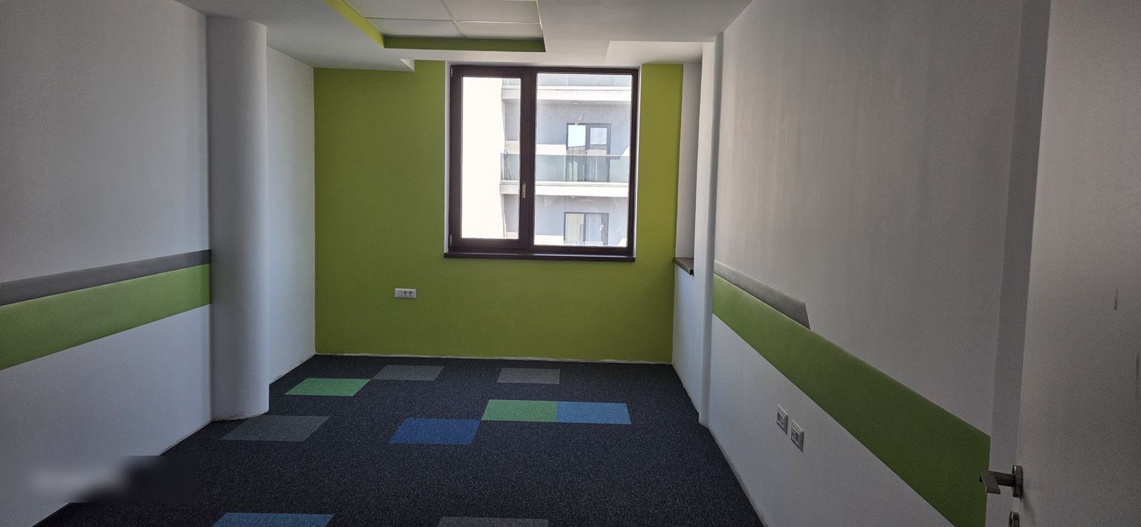 Birou modern luminos cu mochetă și perete verde accent